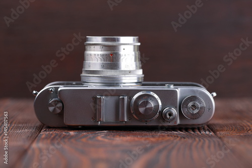 The old rangefinder camera on a wooden background.