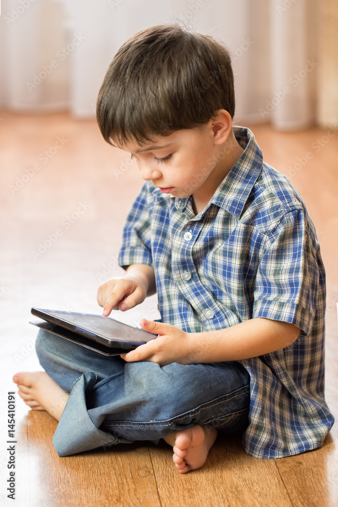 The boy with the tablet was very surprised at what he saw. Strong surprise. Optical distortion of the picture. The boy with the tablet was very surprised at what he saw. Strong surprise. Optical distortion of the picture.