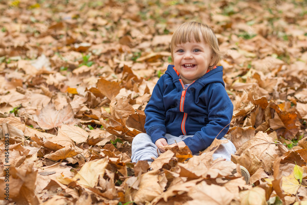 Happy little child, baby boy laughing and playing in autumn Happy little child, baby boy laughing and playing in autumn