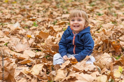 Happy little child  baby boy laughing and playing in autumn
