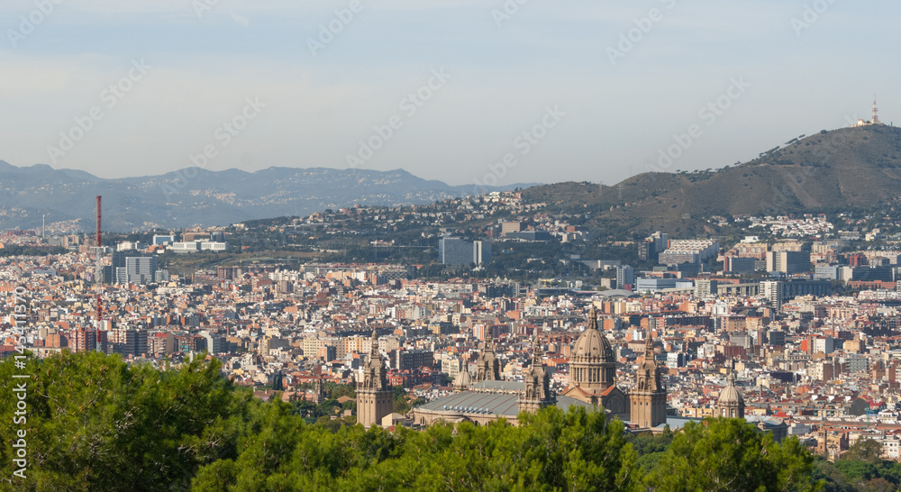 Barcelona cityscape view from high a level, cable car as it passes over tree tops providing views of the city. 