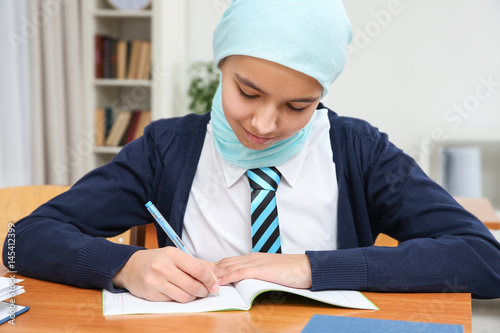 Cute girl sitting at desk i...