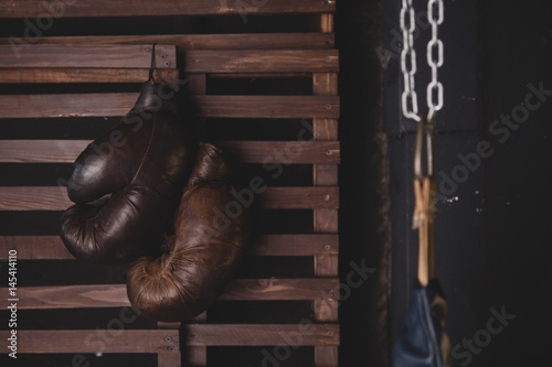 Boxing gloves hanging on wooden wall © daniil