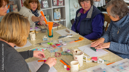Group of women in art class learning how to make polymer clay jewellery