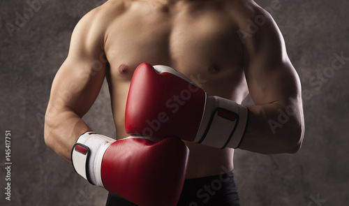 Young muscular man boxer, boxing gloves 