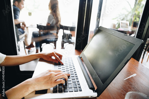 Student women use laptop computer in modern art cafe