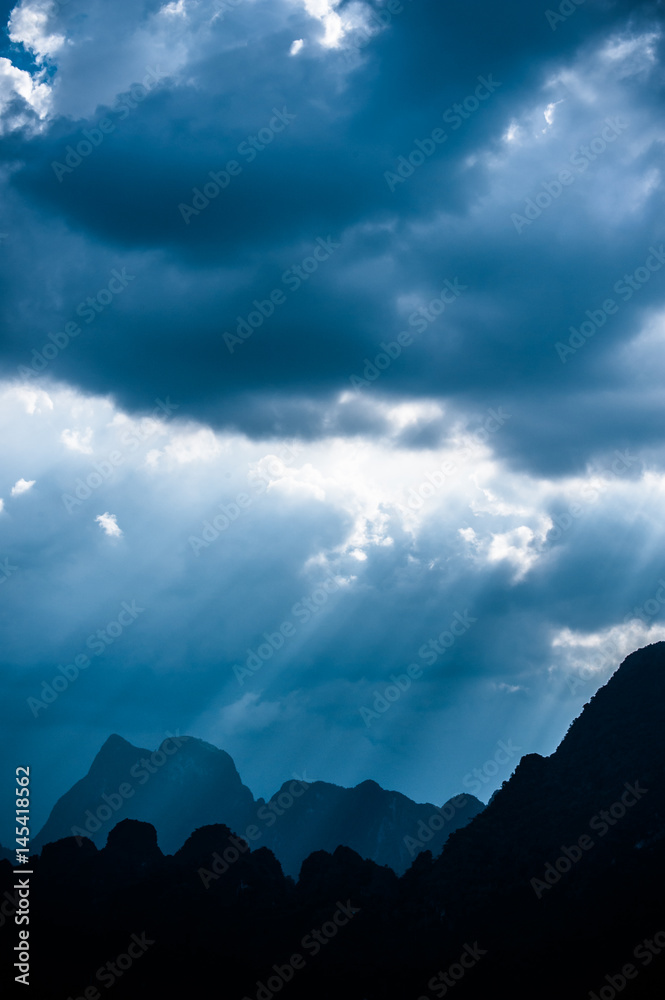 Beautiful sun rays through the clouds over mountains,evening light,Amazing scene at Khao-Sok National Park of Thailand