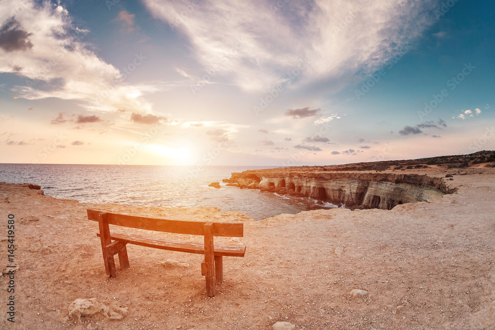 sunset in Cyprus - Mediterranean Sea coast. Sea Caves near Ayia Napa. the bench in the background of space. you can sit and think about life.