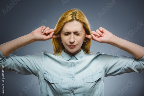 Closeup portrait of worried woman covering her ears, observing. Hear nothing