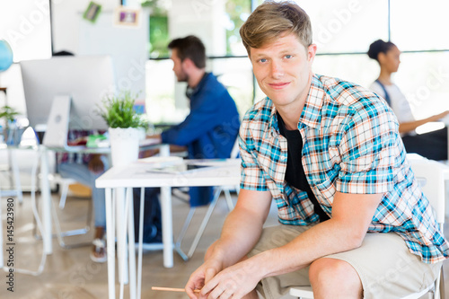 Young man sitting and looking at camera in office