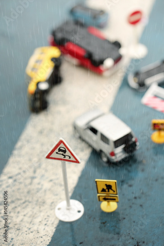 Scene of cars (miniature, toy model ) accident on rainy day,slippery road sign.