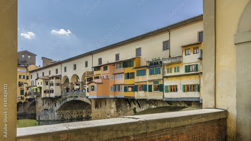 Beautiful glimpse of the famous Ponte Vecchio in the historic center of Florence, Italy, framed by an arch of the Vasari corridor
