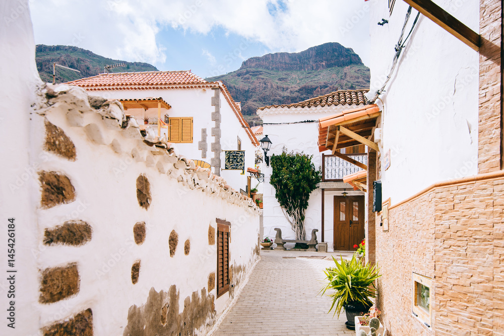 Cozy village with white houses and tiles on the background of mountains in the Canary Islands