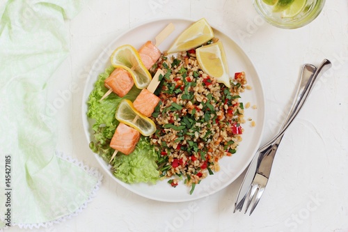 Tabbouleh and salmon skewerws.Traditional bulgur salad with vegetables and herbs. Selective focus  photo