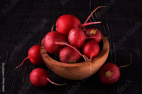 Organic red radish on dark wooden
