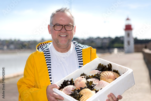 Fotografie Portrait of a senior fisherman with scallop he just  collect