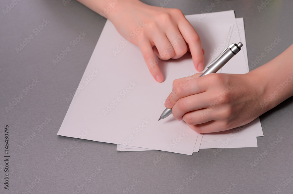 Human hands with pencil writing on paper and erase rubber on wooden table background Human hands with pencil writing on paper and erase rubber on wooden table background