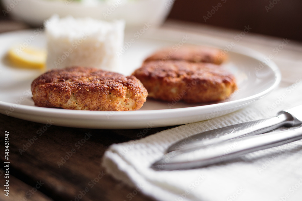 Three fish breadcrumbed cutlet on white plate with rice. Restaurant menu background Three fish breadcrumbed cutlet on white plate with rice. Restaurant menu background