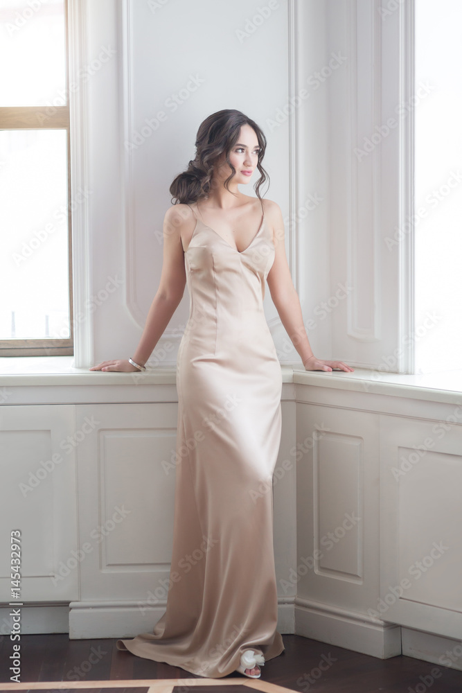Portrait of beautiful young bride in Boudoir dress indoors in interior with a big window home Portrait of beautiful young bride in Boudoir dress indoors in interior with a big window home