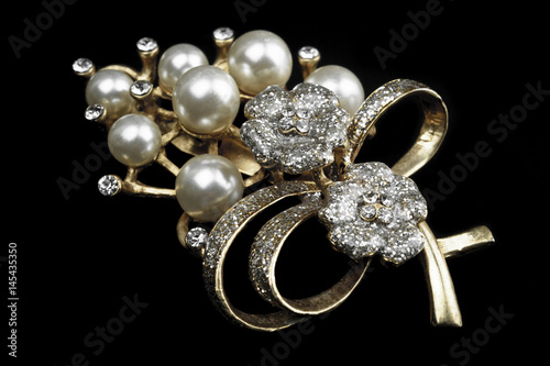 gold and white jewelry with dark background. low key picture style of commercial product.