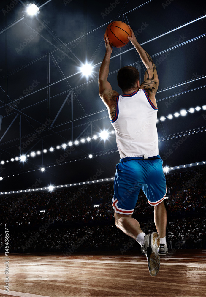 one basketball player jumping with ball on stadium in lights