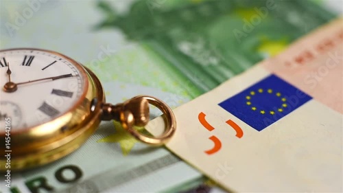 vintage pocket watch and euro currency. close up photo