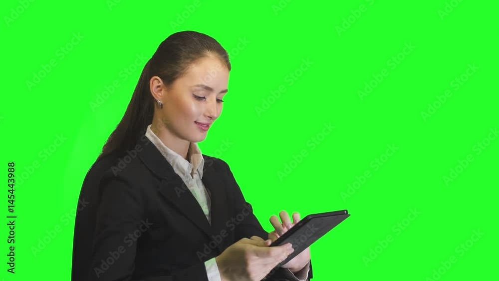 young business woman working on tablet and smiling on a green background young business woman working on tablet and smiling on a green background