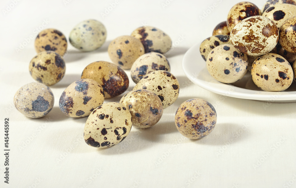 Quail eggs in a white bowl on a white
