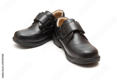 pair of black leather shoe for children on white background © Freer