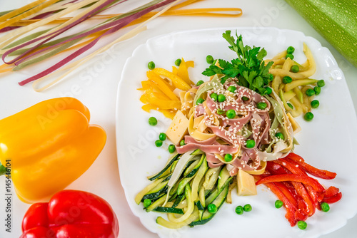 Multi-colored noodles with sesame, vegetables and herbs photo