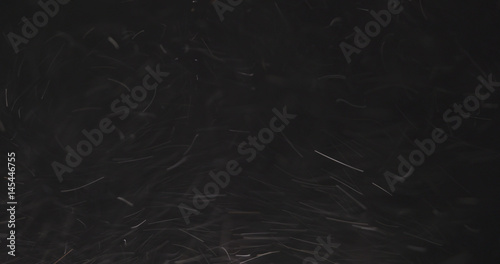 dust particles fast moving over black background from right, 4k photo