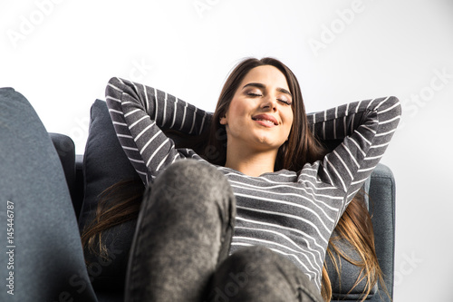 woman relaxing sitting on a couch with the hands on the head on white background