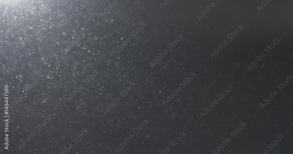 dust particles fast moving over black background from left corner, 4k photo
