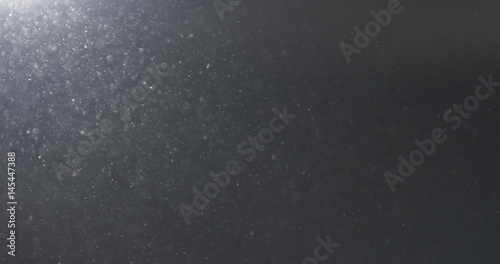 dust particles fast moving over black background from left corner, 4k photo © GCapture