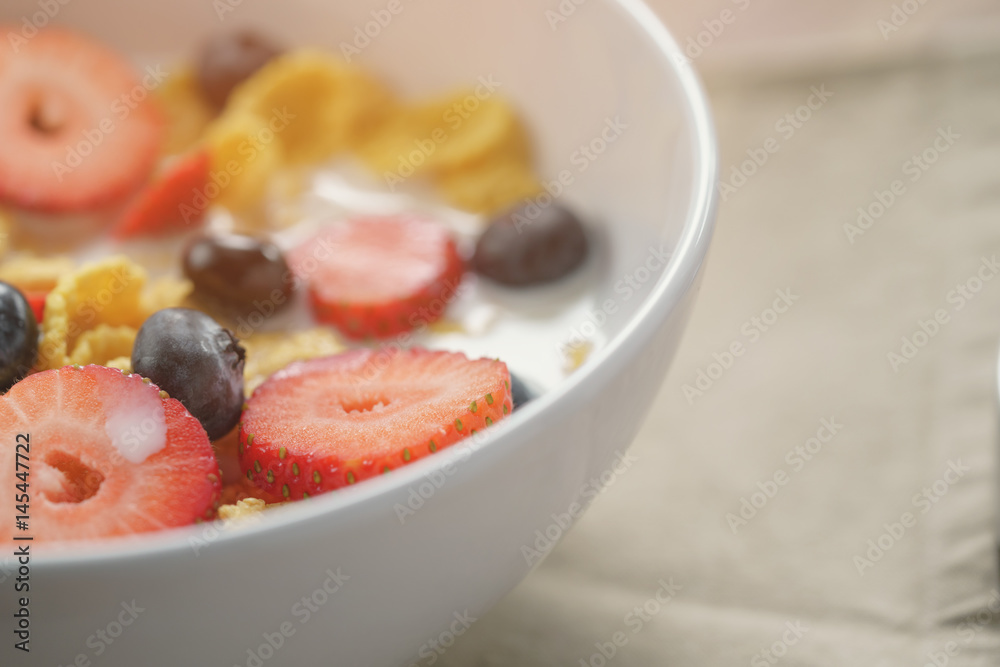 closeup of healthy breakfast with corn flakes and berries in white bowl, slightly toned photo closeup of healthy breakfast with corn flakes and berries in white bowl, slightly toned photo
