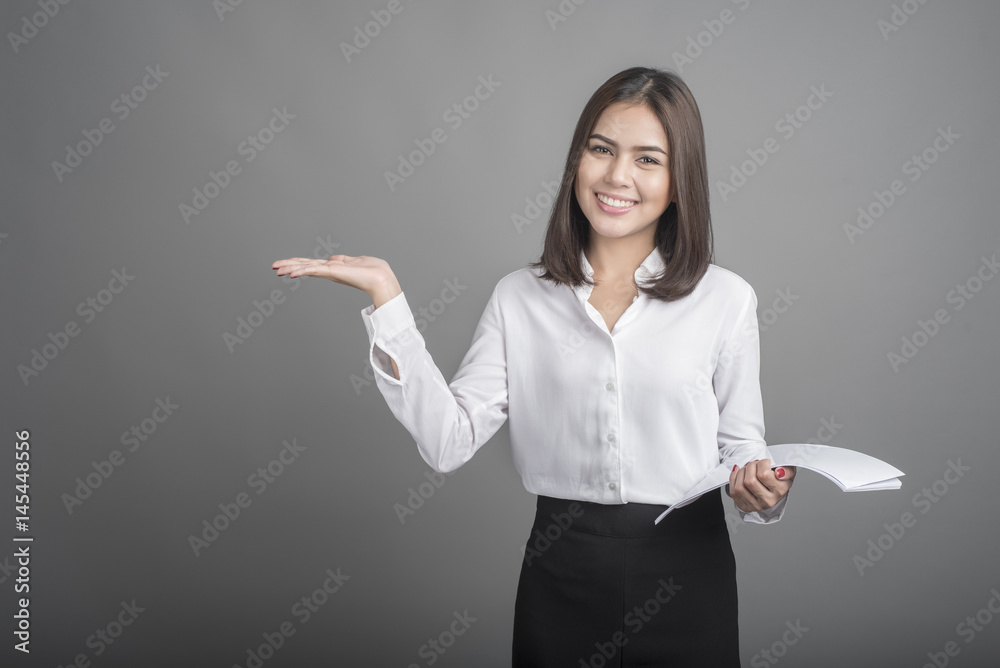 Beautiful Business Woman presenting something on grey background
