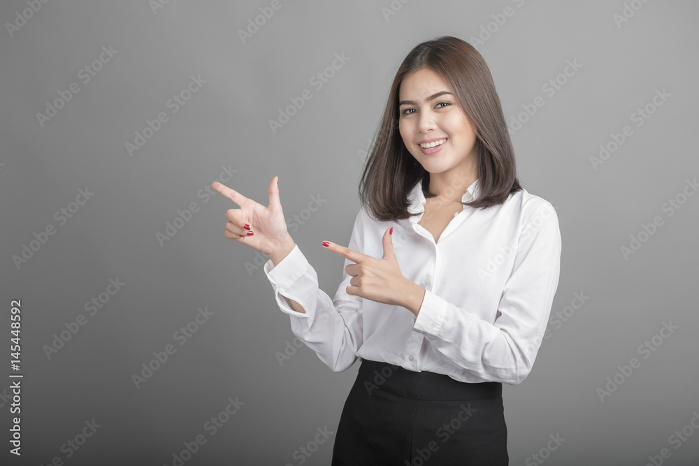 Beautiful Business Woman presenting something on grey background Beautiful Business Woman presenting something on grey background