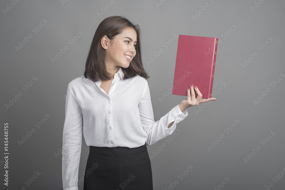 Beautiful teacher Woman holding book on grey background Beautiful teacher Woman holding book on grey background