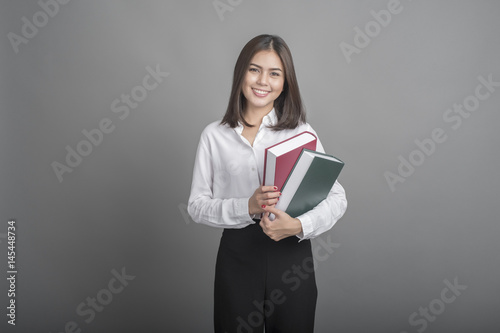 Beautiful teacher Woman holding book on grey background