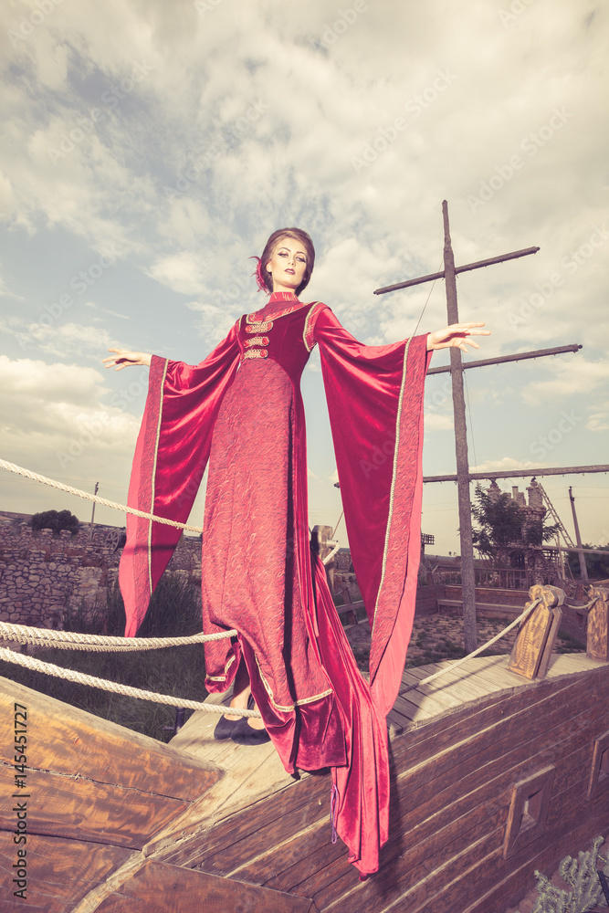 Fototapeta premium Beautiful woman in vintage clothes on a boat. Retro style. Elegance and glamour