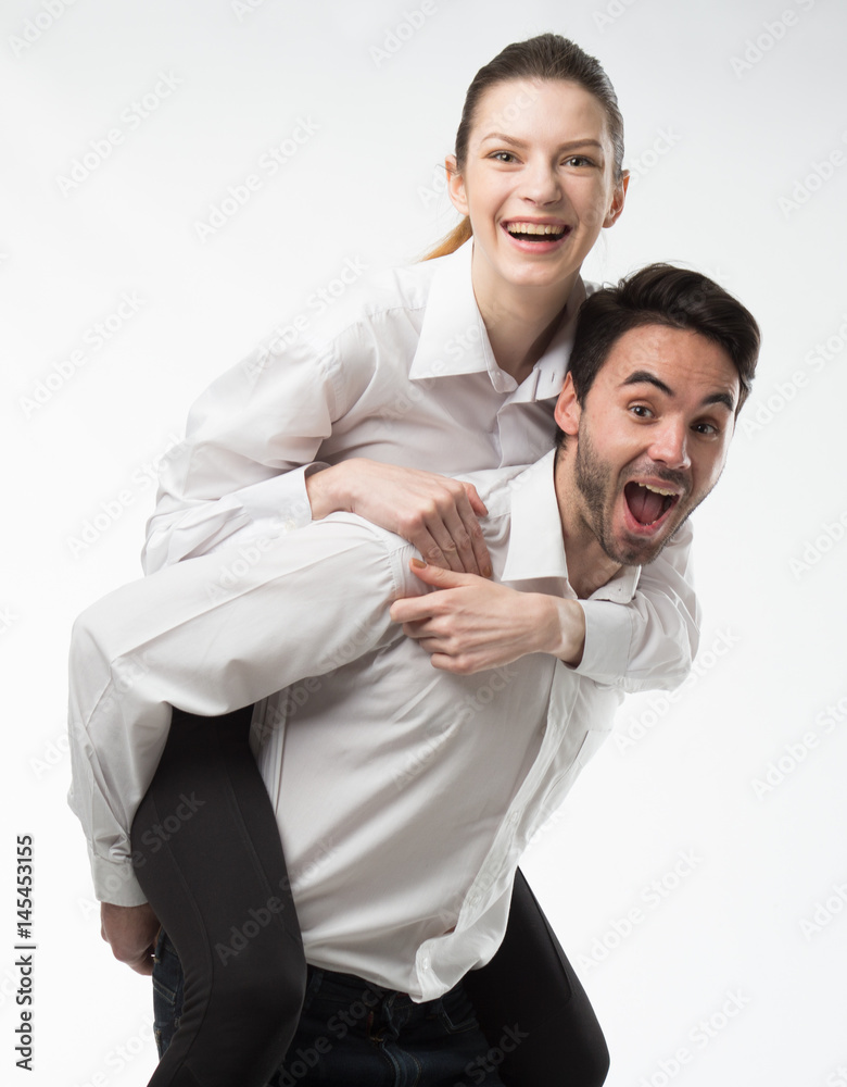 Young happy couple showing presentation pointing on placard over gray background Young happy couple showing presentation pointing on placard over gray background