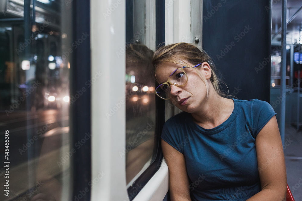 Young woman riding a public bus at night
