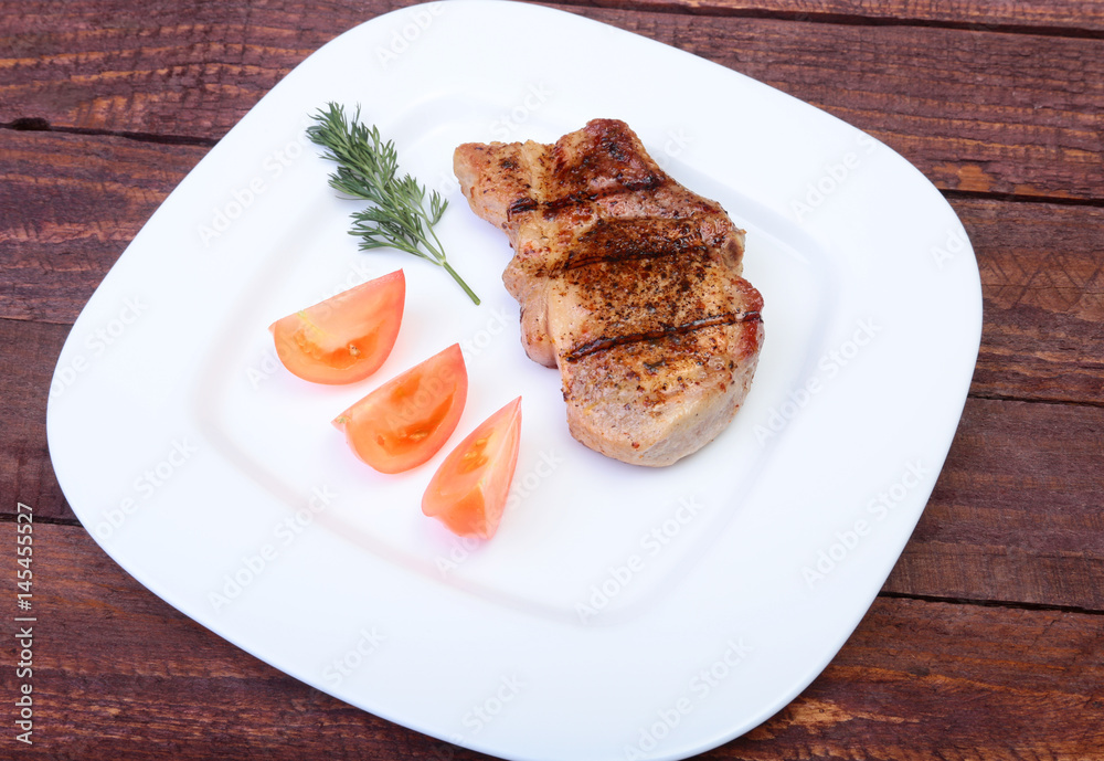 grilled pork chop with vegetable on plate on wooden board grilled pork chop with vegetable on plate on wooden board