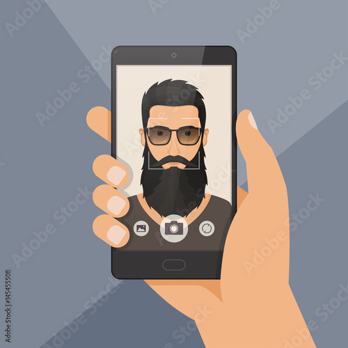 Hipster bearded man lumberjack takes selfie using a smartphone.