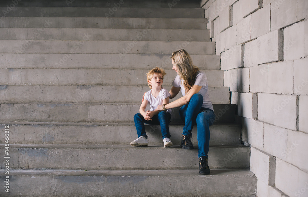 Mother with son sitting on a stairs 