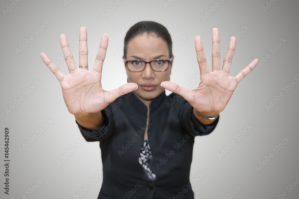 Asian woman leader lift hands signaling stop or defense on gray background.Woman leader concept.Have cipping path. Asian woman leader lift hands signaling stop or defense on gray background.Woman leader concept.Have cipping path.