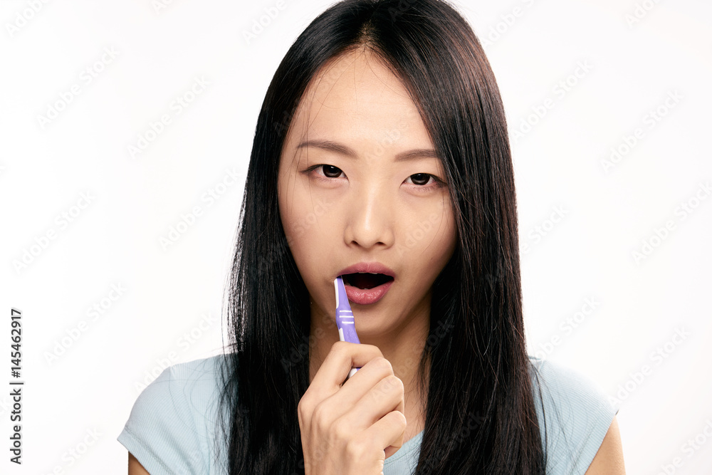 Woman with open mouth brushing her teeth Woman with open mouth brushing her teeth