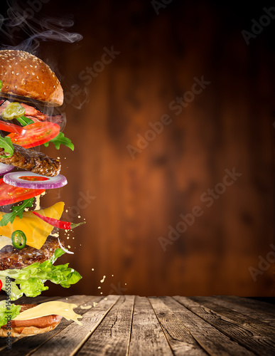 Big tasty burger with flying ingredients.