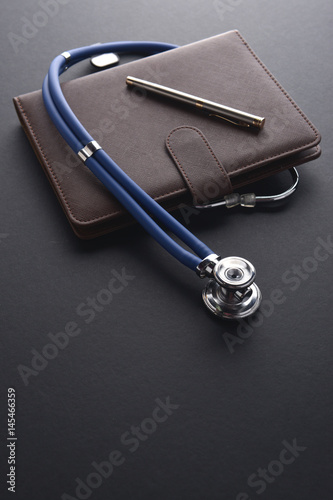 Stethoscope on book and pen. Medical or insurance conceptual