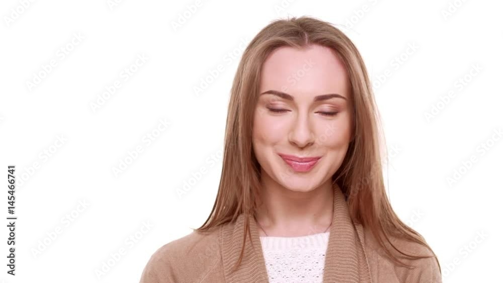 Charming young Caucasian female seductively looking at camera and smiling on white background in slowmotion Charming young Caucasian female seductively looking at camera and smiling on white background in slowmotion